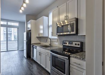a kitchen with white cabinets and stainless steel appliances
